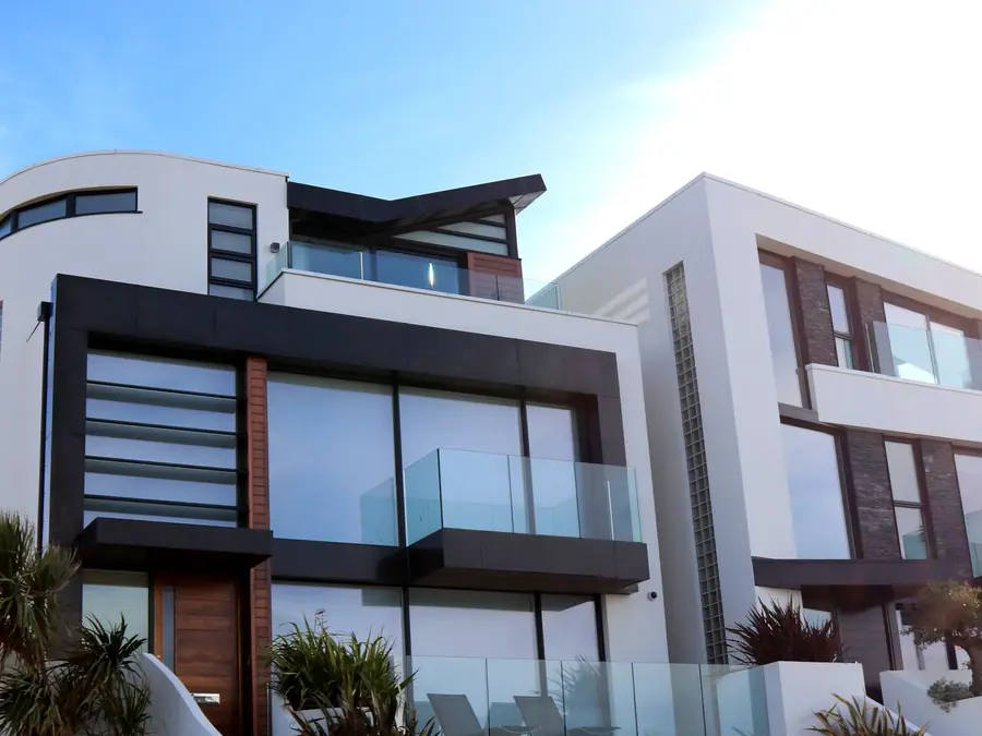 Residência moderna com sacadas de vidro e volumes brancos